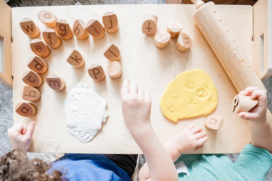 Children using Montessori Alphabet Stamps with dough