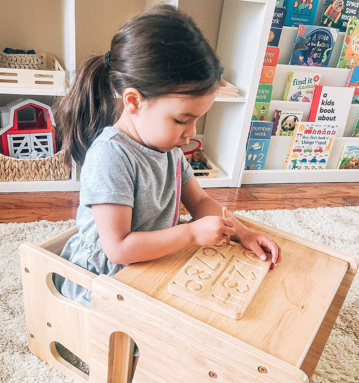 Child tracing numbers on the Montessori Wooden Number Tracing Board