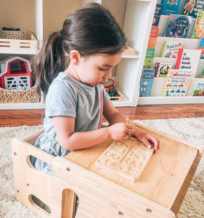 Child tracing numbers on the Montessori Wooden Number Tracing Board